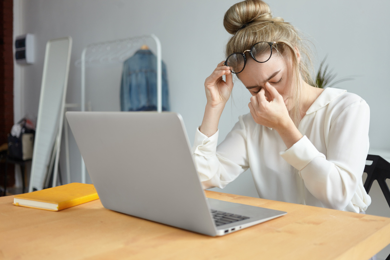 Tired young woman in front of a laptop