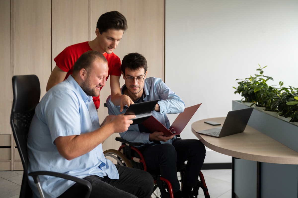 Three young men sitting in an office in front of the tablet, laptop and documents